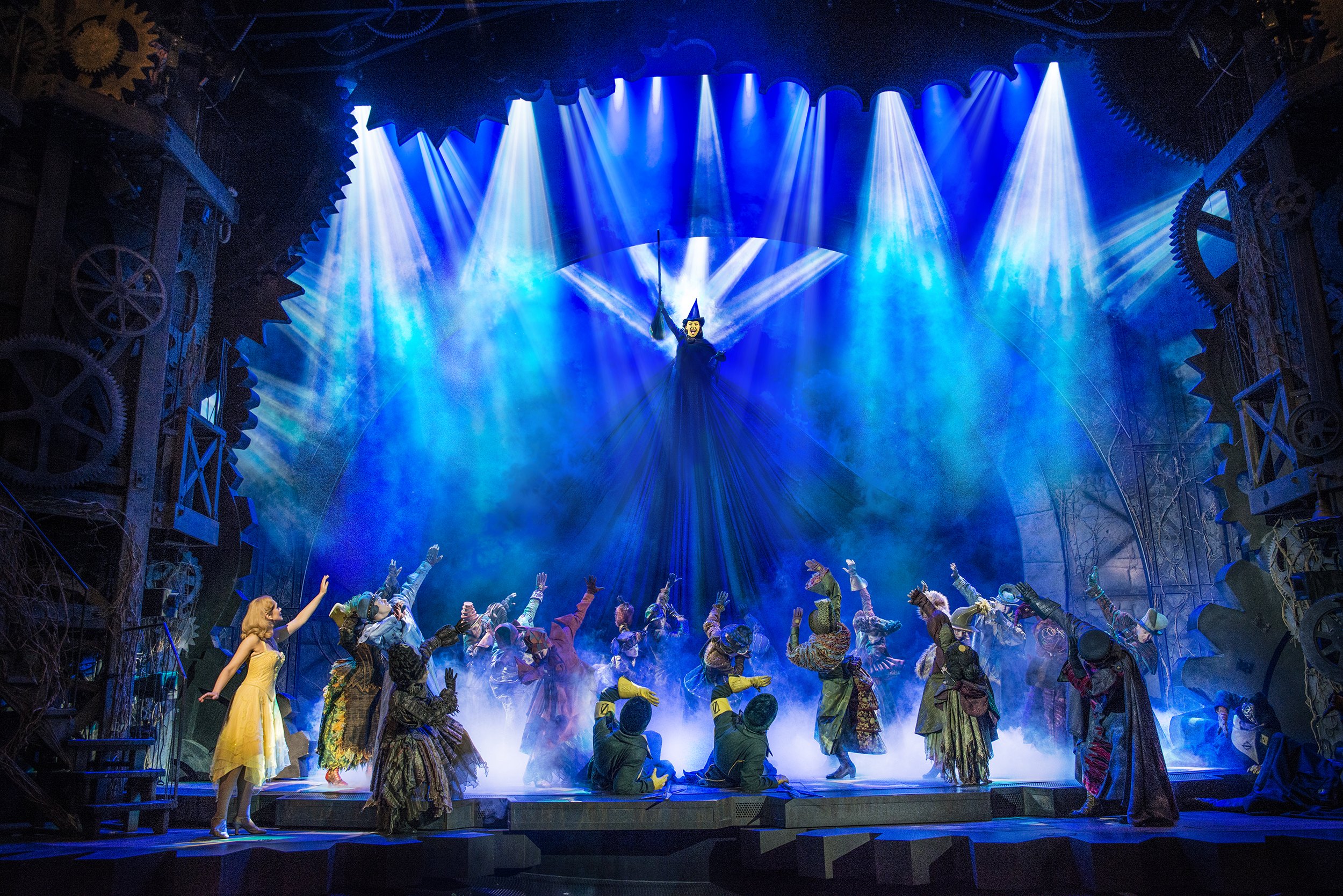 A full stage shot of Elphaba defying gravity with the guards and Glinda watching below.