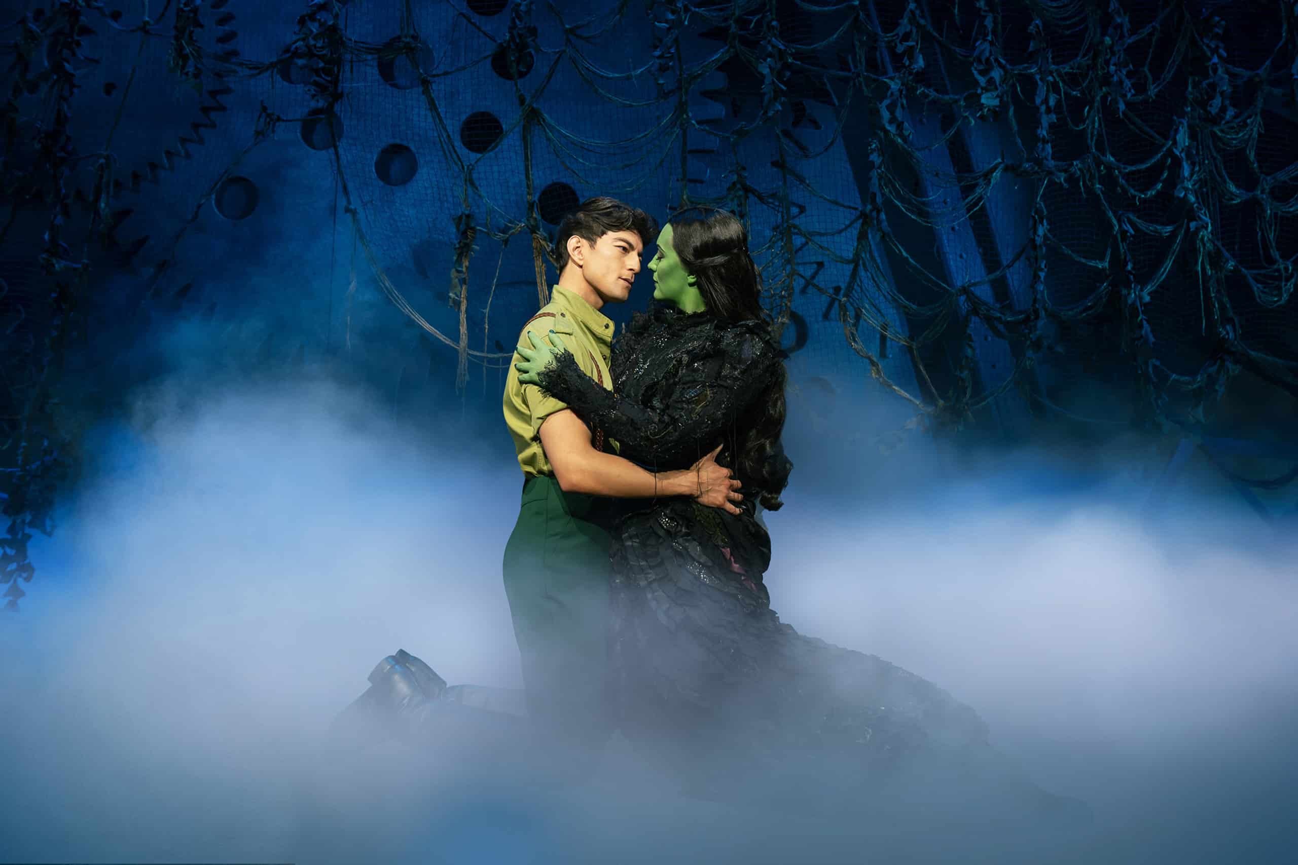 Fiyero and Elphaba kneeling surrounded by smoke